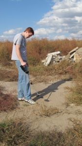 Matthew Cantril uses a metal detector near a possible campground site.