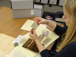 Jessica sorts through the contents of George's wallet, examining his registration card. 